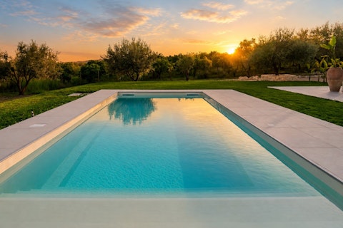 Swim as the sun sinks behind ancient olive trees