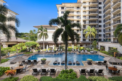 Stretch out by the shared pool beneath Hawaiian palm trees