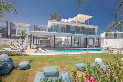 Stretch out on the lawn while the pool gleams beside you