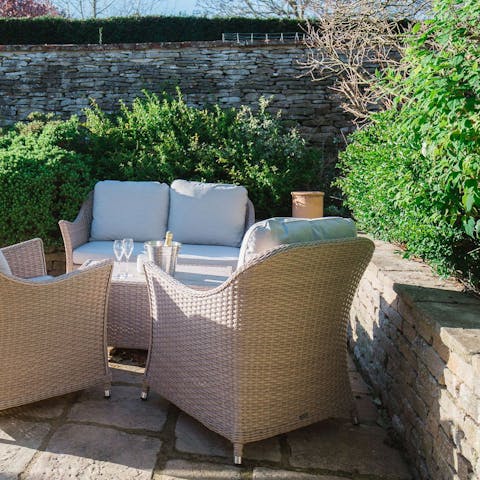 Relax on the garden furniture with a glass of English sparkling wine at sunset