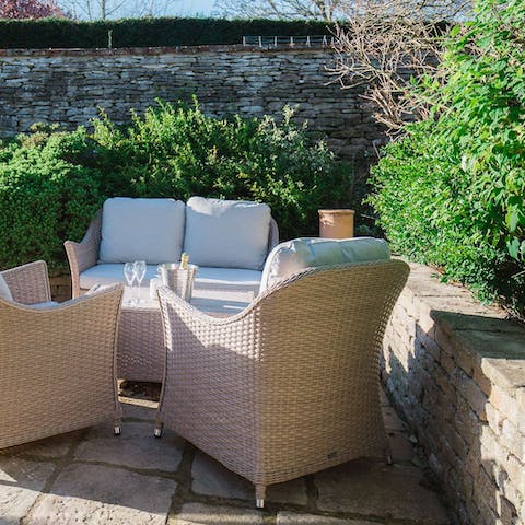 Relax on the garden furniture with a glass of English sparkling wine at sunset
