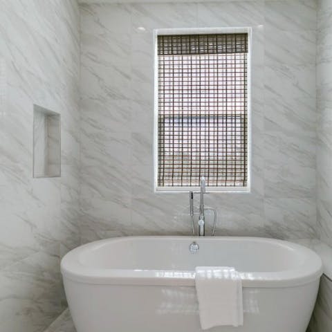Slope away for a soak in the freestanding bathtub