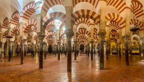 Marvel at the Mezquita-Catedral's breathtaking forest of striped arches and gilded mihrab, a seventeen-minute walk