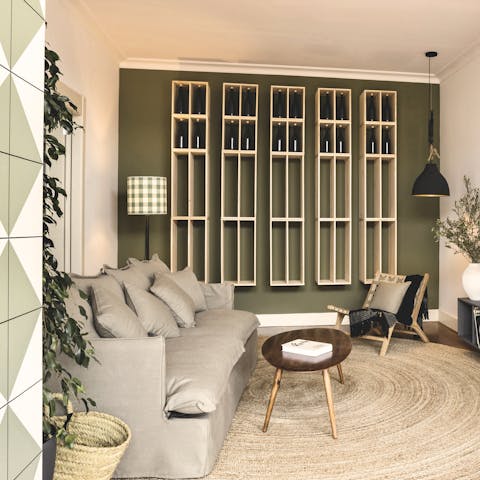 Kick back on the plump sofa next to the feature shelving wall