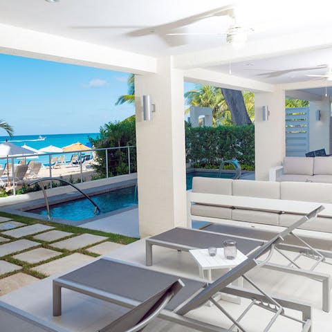 Laze on loungers on your covered terrace while gazing out to sea