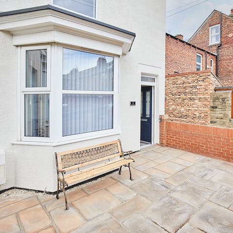 Enjoy a fresh cup of coffee on the front patio's bench