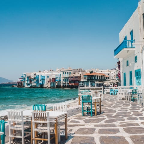 Mingle with locals in the old port of Mykonos – a thirteen–minute drive away