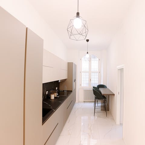 Prepare espresso and cornetti in the sleek kitchen to start the day