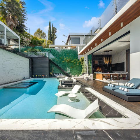 Lounge around the private pool by day