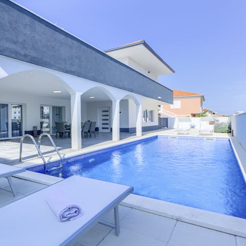 Enjoy a refreshing dip in the swimming pool, then dry off on a sun lounger