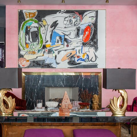 Come together around the marble and gold tinted fireplace