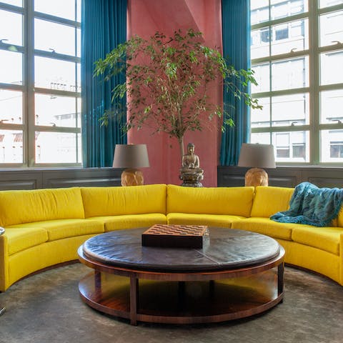 Unwind with a game of chess on the striking, yellow semicircular sofa