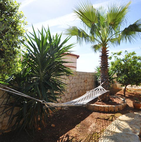 The home is surrounded by lush gardens and plenty of shady spots to relax