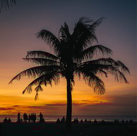 Watch the sun set at Seminyak Beach – a ten-minute drive away