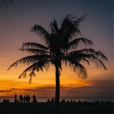 Watch the sun set at Seminyak Beach – a ten-minute drive away