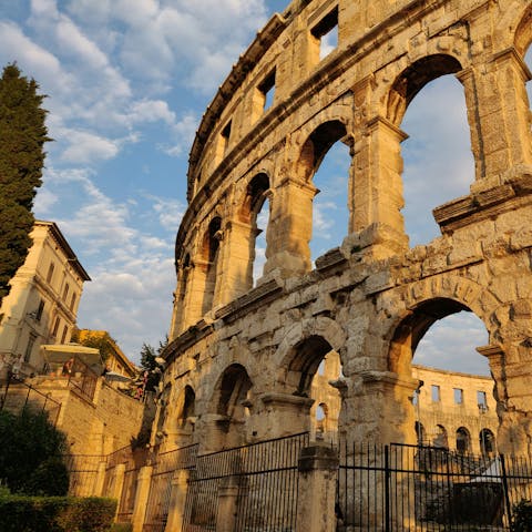 Visit the Roman amphitheater in Pula, an eighteen-minute drive away