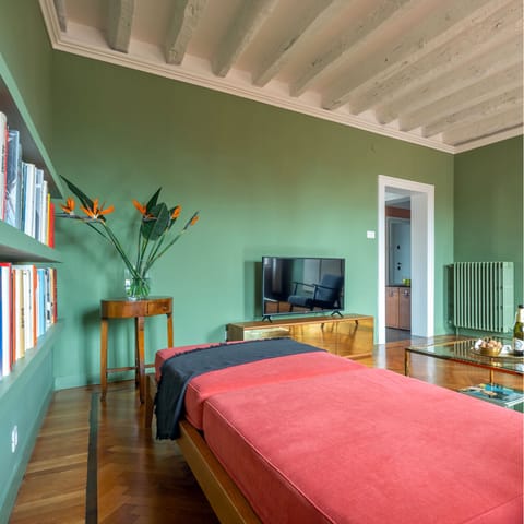 Relax in the calming sage green living room with a good book