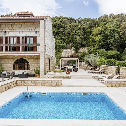 Cool off with a refreshing dip in the outdoor pool – partially shaded by towering palm trees