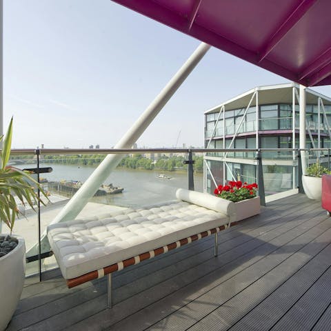 Relax on the wrap-around balcony with views across the River Thames