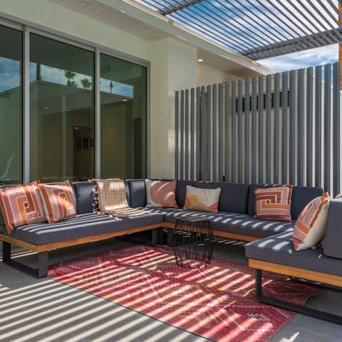 Lay back on the comfy U-shaped sofa in the shade outside