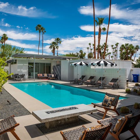 Cool off with a dip in the swimming pool as the towering palms sway in the breeze
