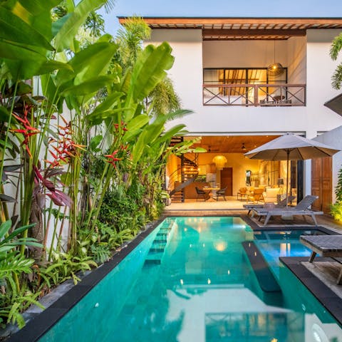 Dive into the private pool amid lush greenery