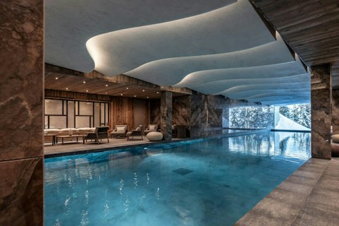 Swim lengths while snow-covered trees line the window