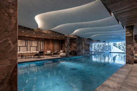 Swim lengths while snow-covered trees line the window