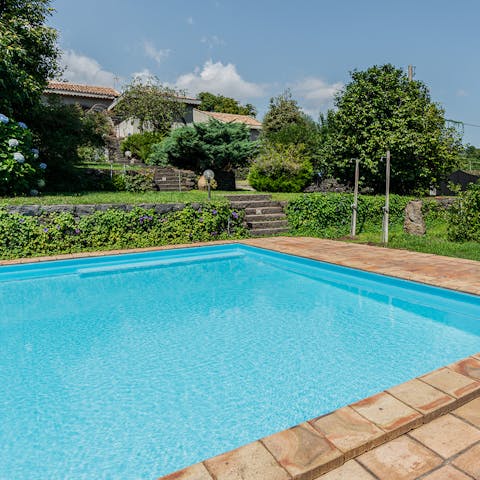 Cool off in the swimming pool surrounded by palms and greenery