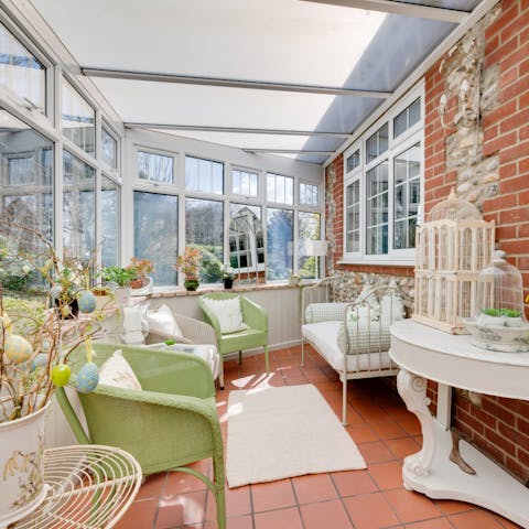 Drink up the garden views and birdsong from the daybed of the pretty sunroom