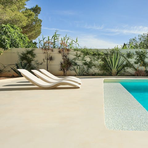 Lounge by the pool, surrounded by lush greenery
