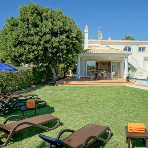 Laze on loungers in the sun surrounded by lush greenery