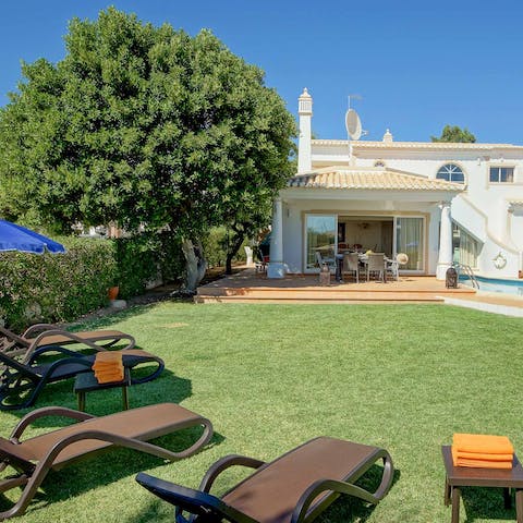 Laze on loungers in the sun surrounded by lush greenery