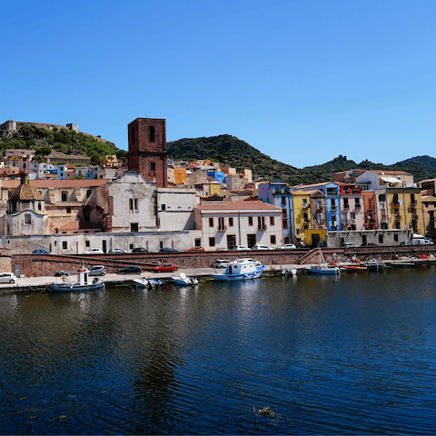 Head to Bosa and admire the pastel houses and hilltop castle