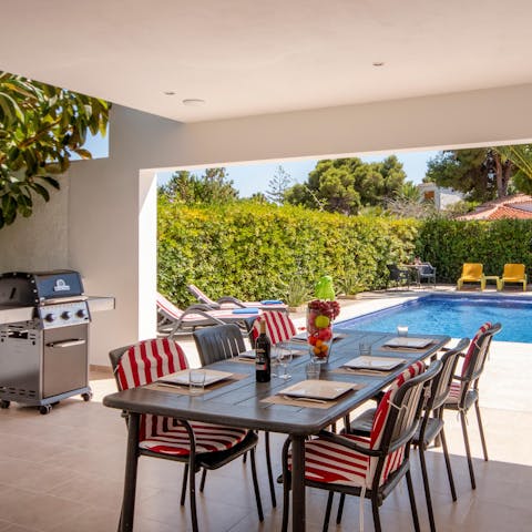 Gather your loved ones on the shaded terrace for a poolside barbecue