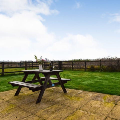 Perch at the picnic table with a cup of tea as the kids play in the garden