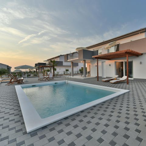 Lounge around the pool with a drink in hand