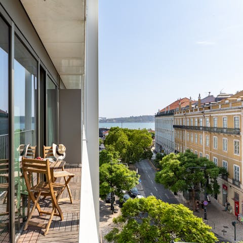 Admire the view of the leafy street and Tagus from the balcony