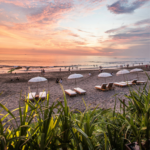 Watch the sunset from Batu Bolong Beach, fifteen minutes away