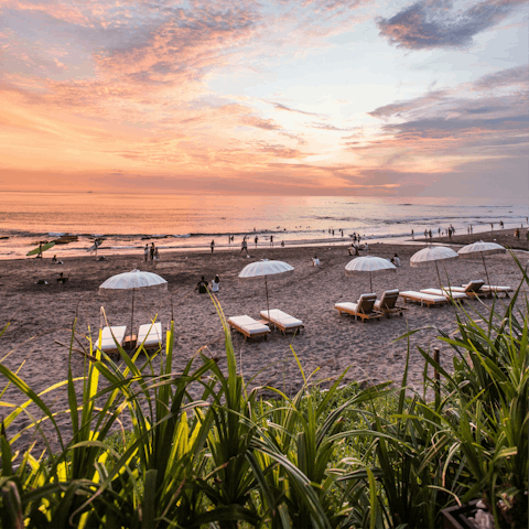 Watch the sunset from Batu Bolong Beach, fifteen minutes away