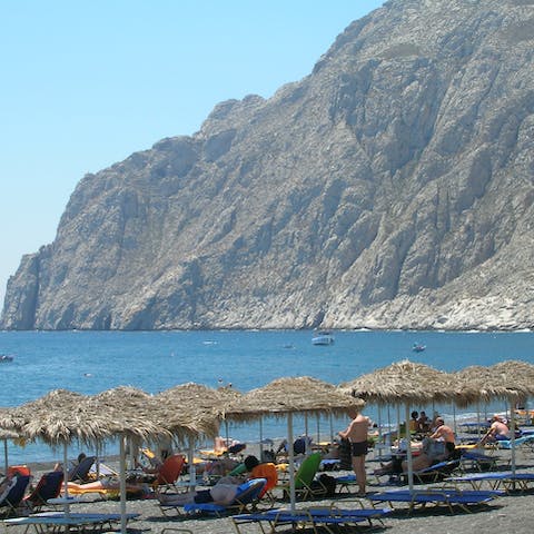 Spend an afternoon relaxing on Kamari Beach, a thirteen-minute drive away