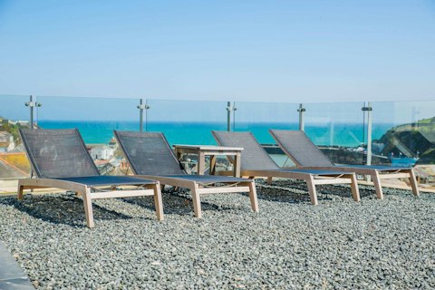 Stretch out on sun loungers above the sea