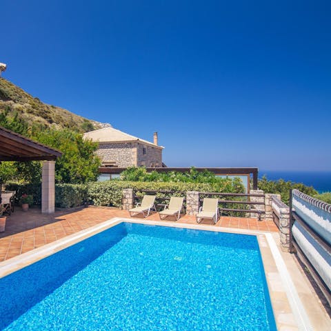 Paddle about elegantly in the swimming pool with the Aegean Sea sparkling in the background