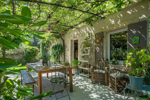 Enjoy a glass of local rosé wine under the vine-covered terrace