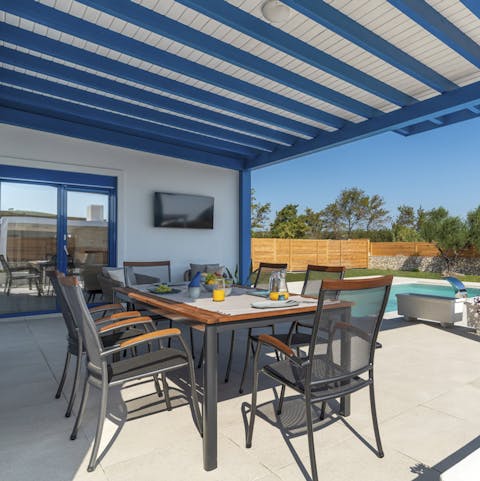 Sit down for an alfresco meal beneath the pergola