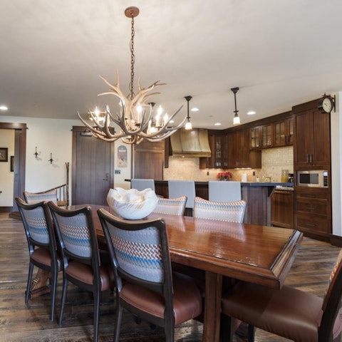 Pull up a chair at the dining table beneath a statement antler chandelier