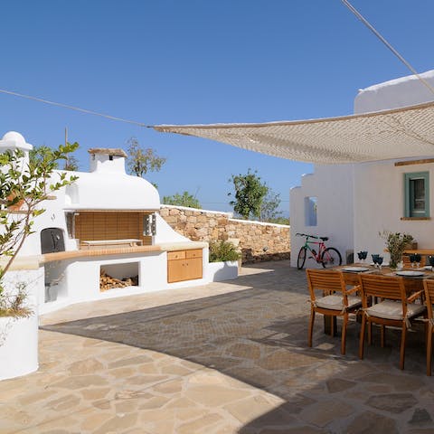 Work culinary magic on the stone barbecue and serve to guests seated on the terrace