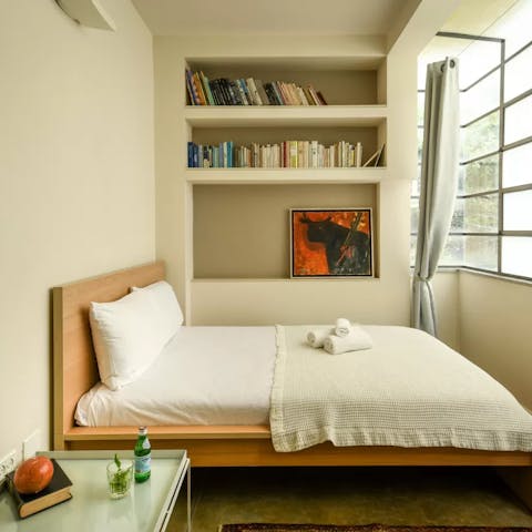 Curl up in the cosy bed with a book from the host's collection