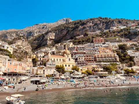 Relax on Positano's iconic pebble beach framed by colourful cliffside houses