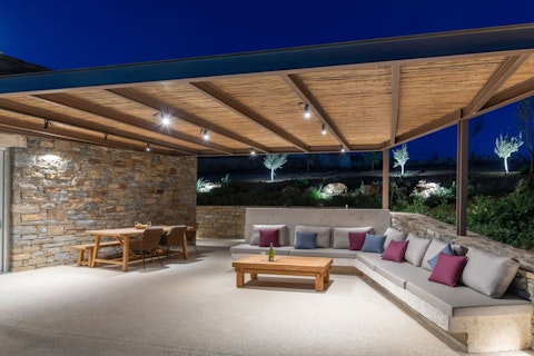 Dine and unwind under a lit pergola as evening falls